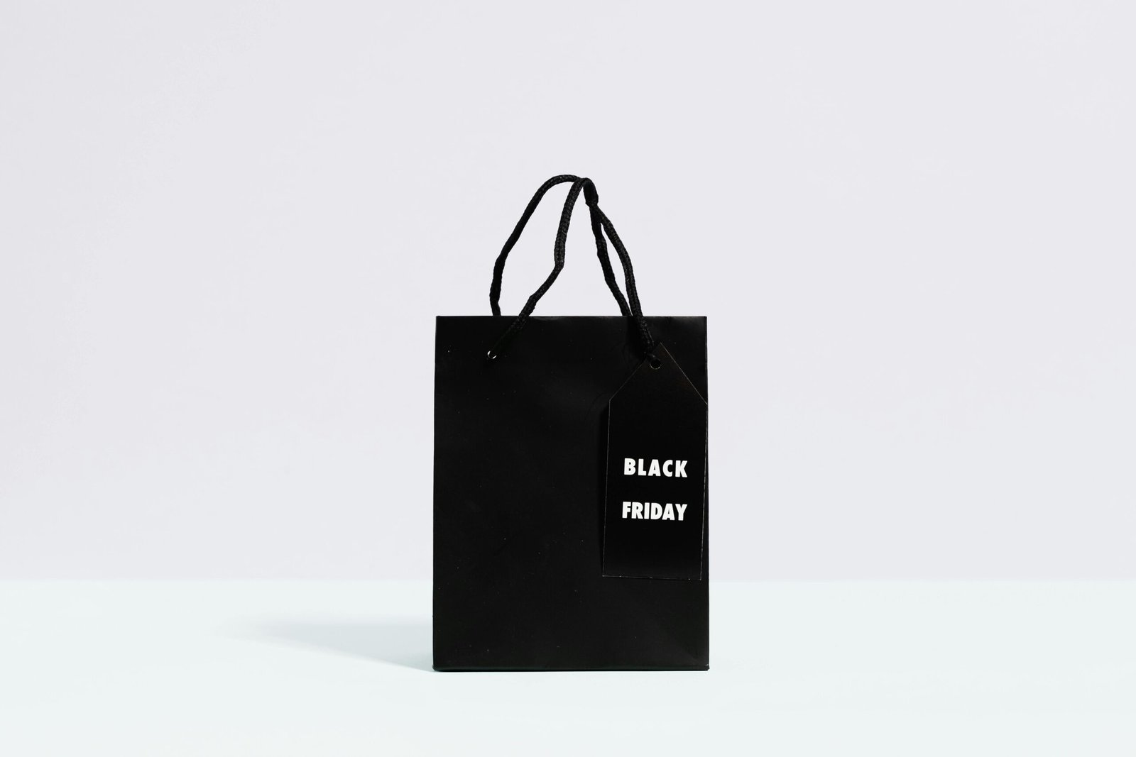 Black Friday shopping bag displayed on a minimalist background, perfect for sale promotions.